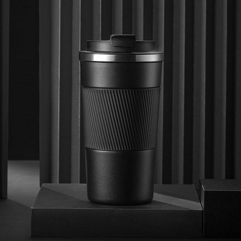 Black leather-wrapped insulated travel mug with ribbed grip and flip-top lid