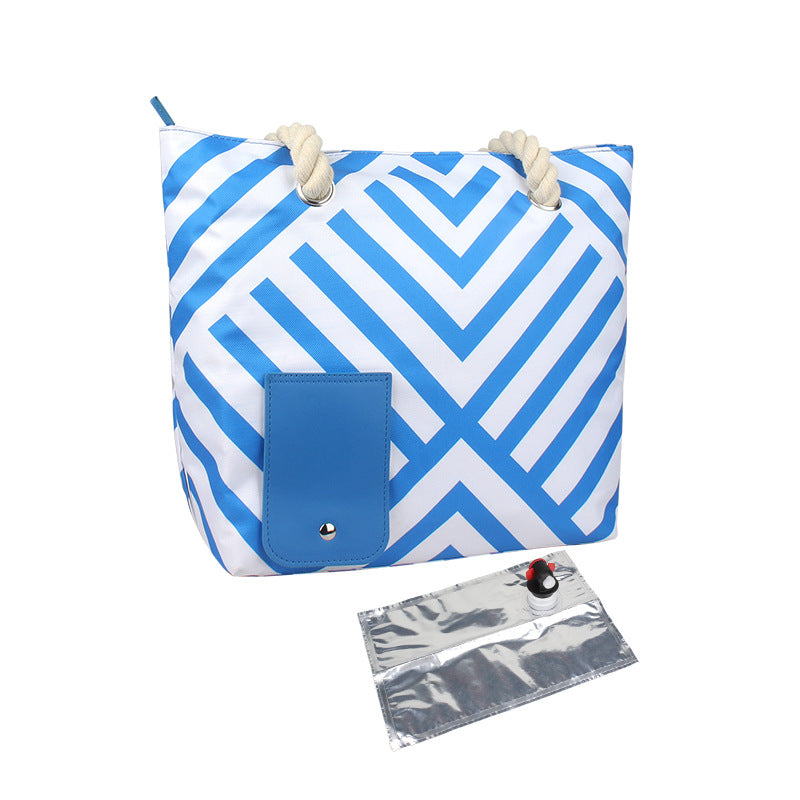 Blue geometric insulated tote bag with rope handles, blue front pocket, and foil sleeve.
