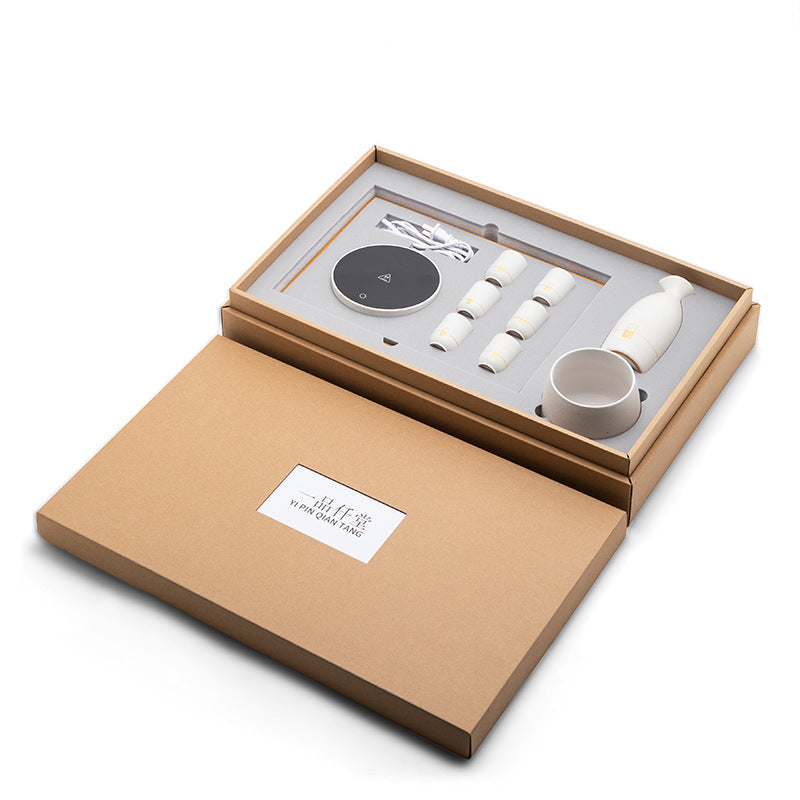 Electric wine warmer gift box with black control pad, ceramic pieces, and accessories