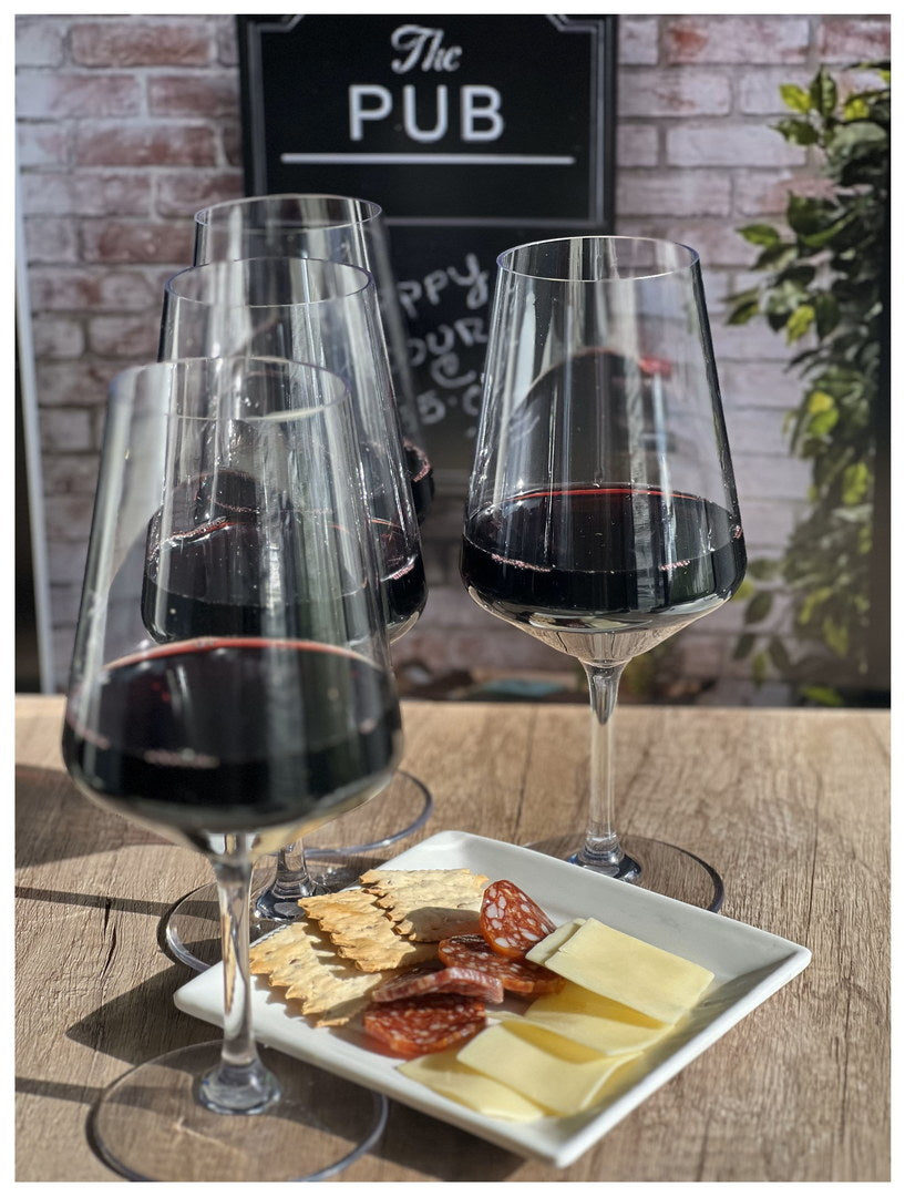 Clear stemmed wine glasses with dark red wine, two glasses on serving tray