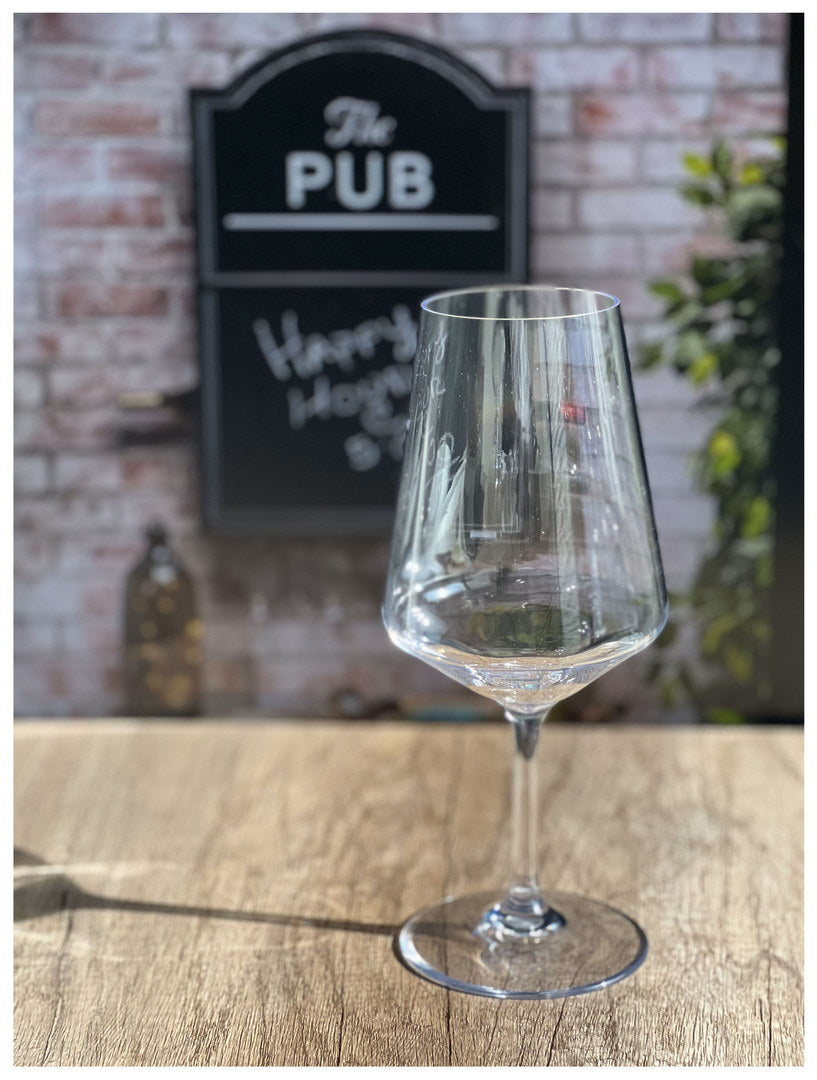 Clear stemmed wine glass filled with dark red wine, upright on table