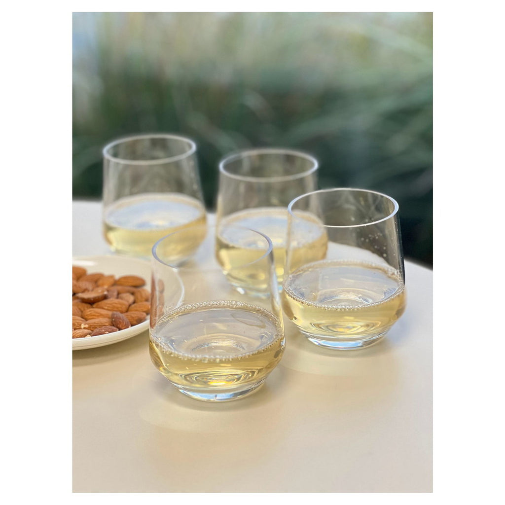 Clear wine glasses with pale yellow beverage and ice cubes