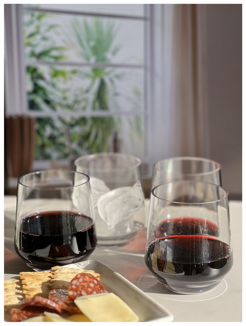 Clear wine glasses with dark red wine, plus ice in one glass