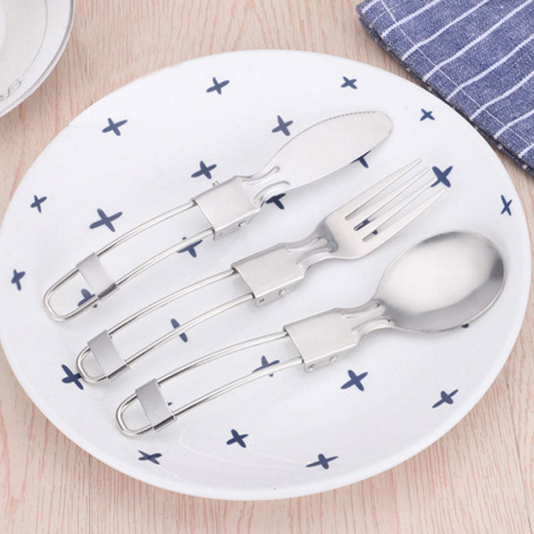 4-piece folding stainless steel cutlery set with spoon, fork, and knife on plate