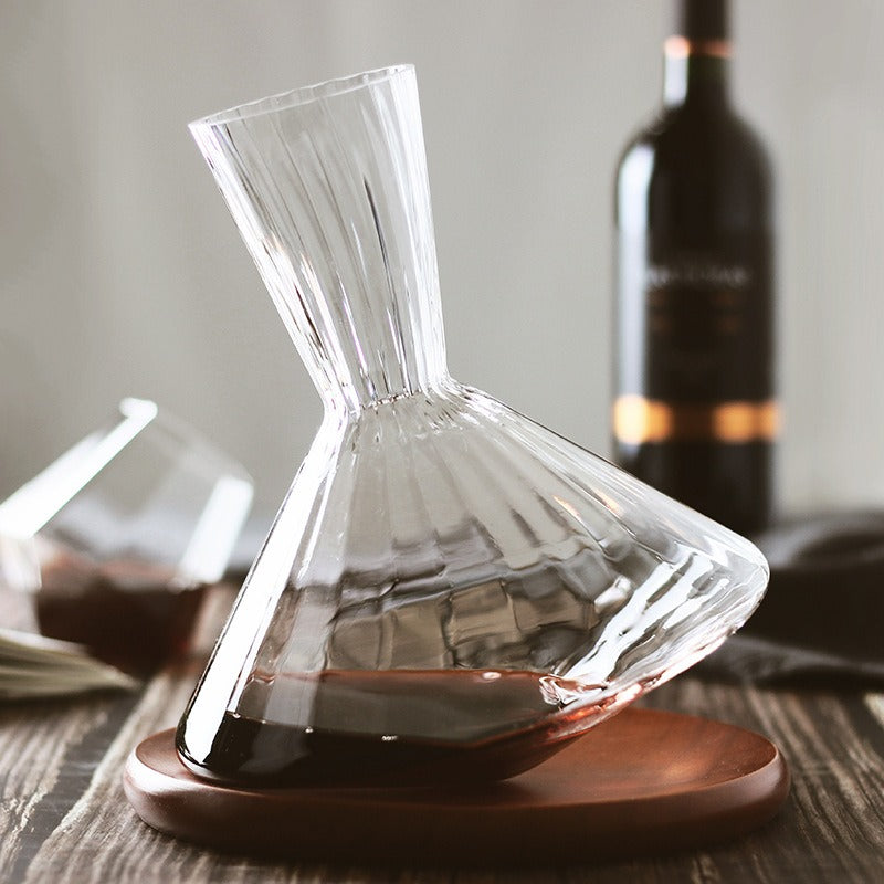 Glass wine decanter with wide base and fluted neck, on wooden tray