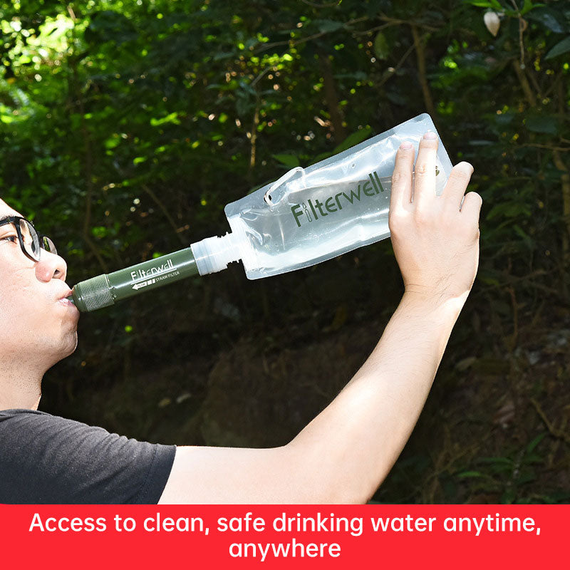 Green mini water filter pipet with drinking tube held up to a person’s mouth
