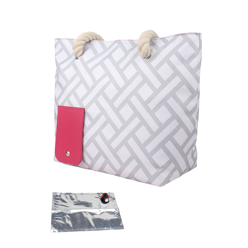 Grey geometric insulated tote bag with pink front pocket, rope handles, and foil sleeve.