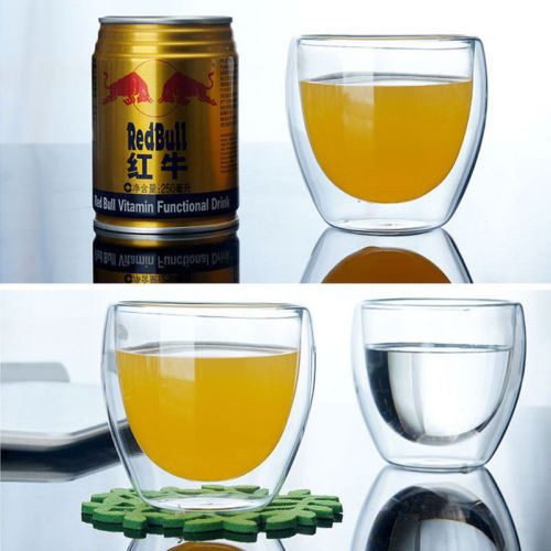 Clear double-wall glass mug filled with golden tea, double-wall reflection visible