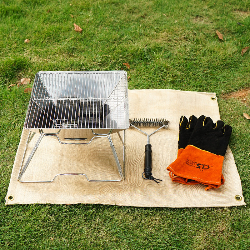 Fireproof camping blanket mat with folded orange cloth, black gloves, and grill kit