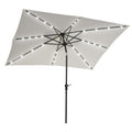 Solar LED patio umbrella with white canopy and black pole, with glowing LED string lights