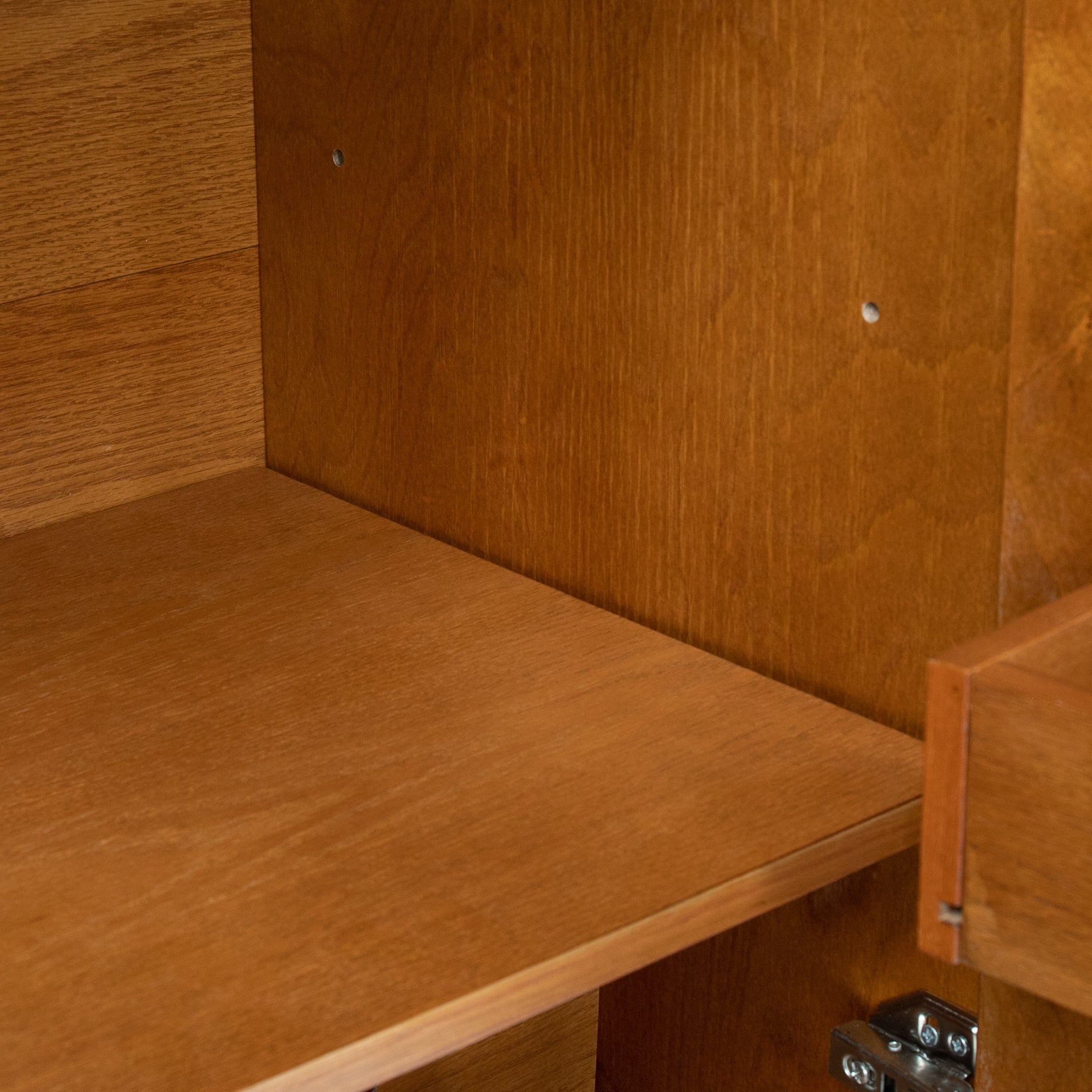 Interior shelf inside wood cabinet with hinge hardware and corner mounting points