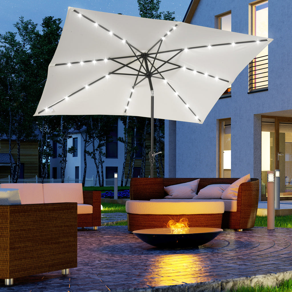 Solar LED patio umbrella with white canopy glowing at night over outdoor seating