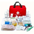 Red first aid kit bag with handle and white medical cross; bandages and supplies laid out