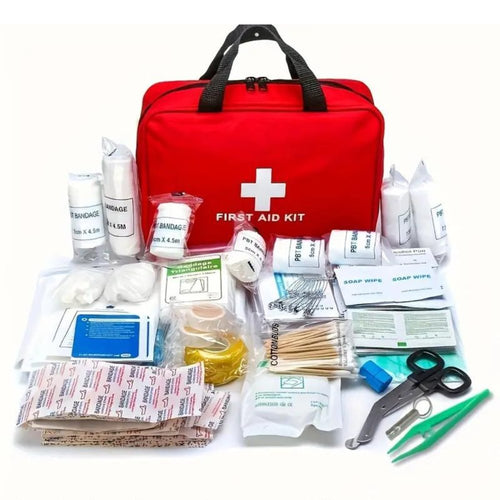 Red first aid kit bag with handle and white medical cross; bandages and supplies laid out